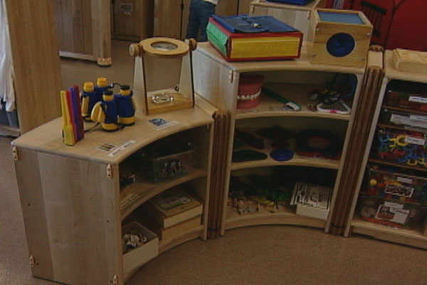 Close-up of a shelf full of toys in a preschool classroom.