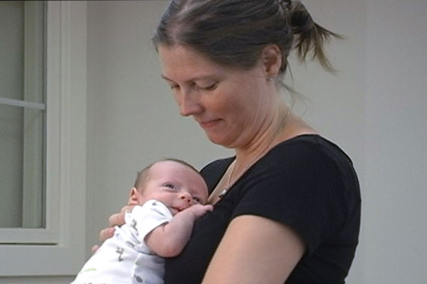 A mother holds and looks at her infant