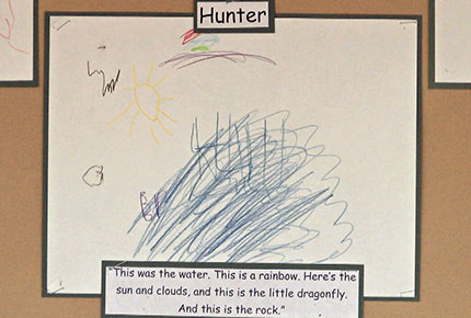 Child's drawing of a pond, with the caption, "This is the water. This is a rainbow. Here's the sun and clouds, and this is the little dragonfly. And this is the rock."