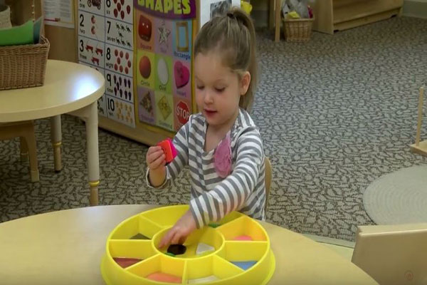 A child sorts large, colorful buttons.