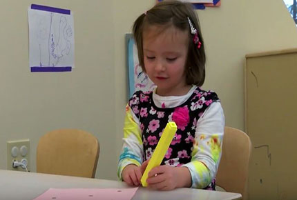 Child holds tweezers and counts. 