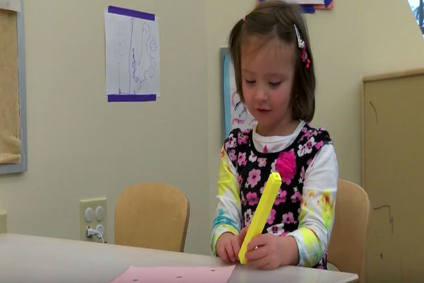 A child uses tweezers to pick up and count objects