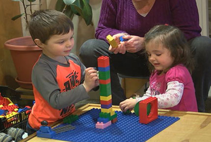 Two children stack legos.