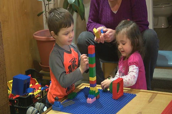 Two children stack legos together.