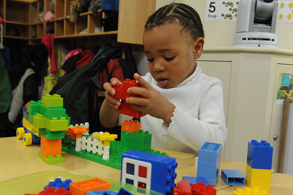 A child builds with duplo blocks. 