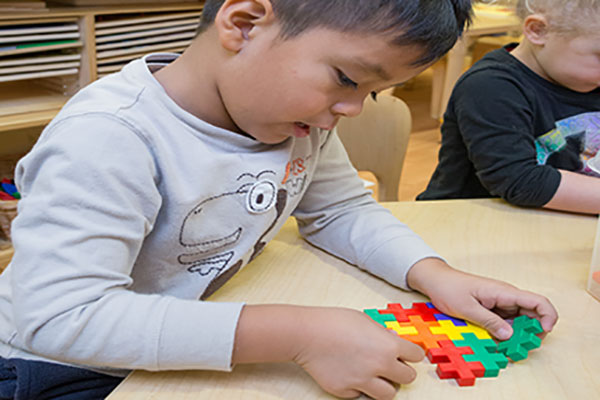 A child playing with plus-plus blocks.