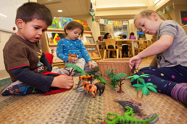 Children playing with plastic animals. 