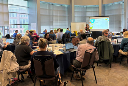 Dr. Cynthia Alby leads a workshop to a full room of faculty
