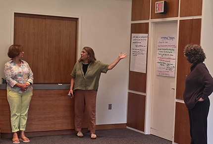 3 faculty discuss what they will write on the flip chart paper on the wall related to Instructional Strategies