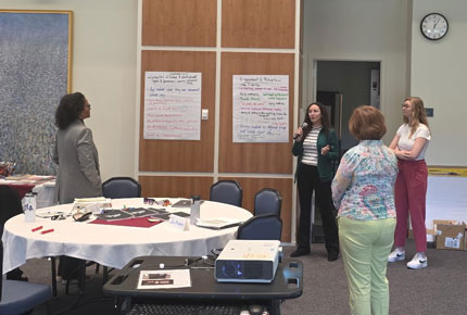 A small group reports out on their work on flip chart paper related to Engagement & Motivation