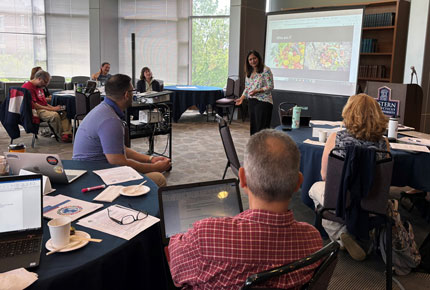 Faculty listen as Dr. Suki Grandhi presents