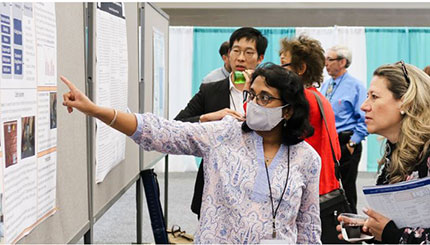 Faculty member giving a poster presentation at a national conference