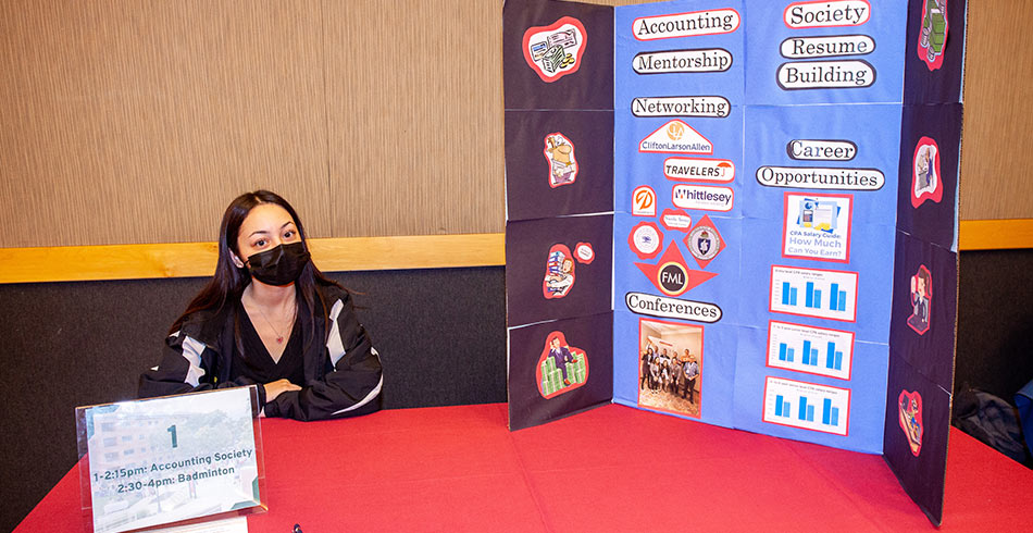 student sitting at club fair