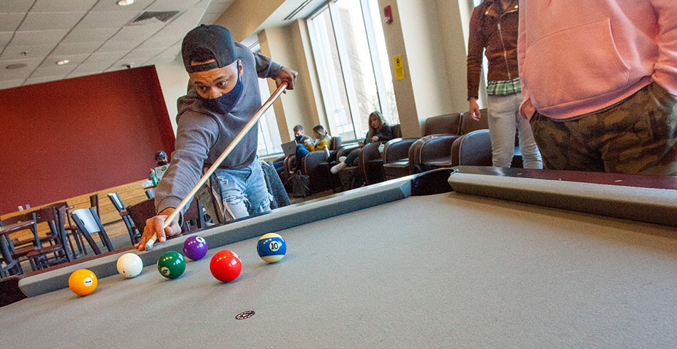 student playing billiards