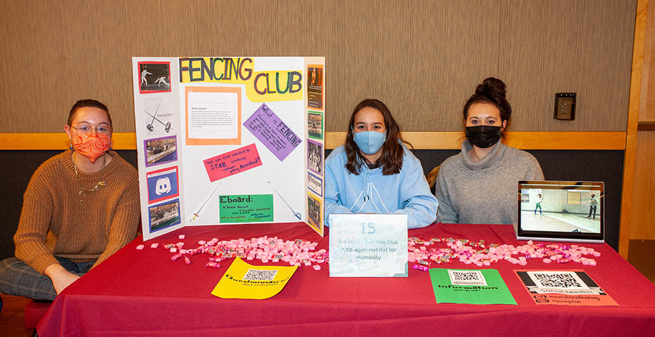 students sitting at their table at the club fair