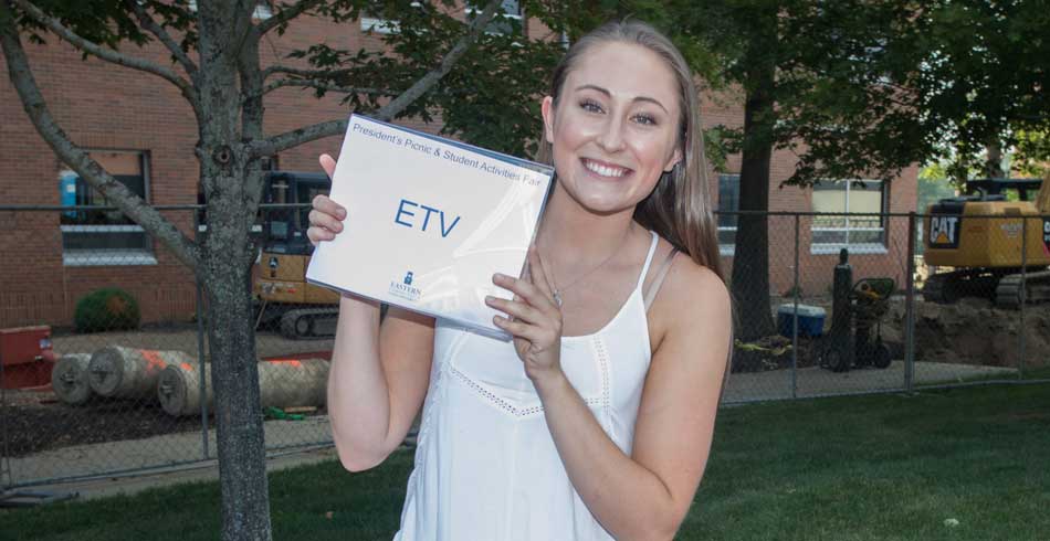 Female club member holding etv sign