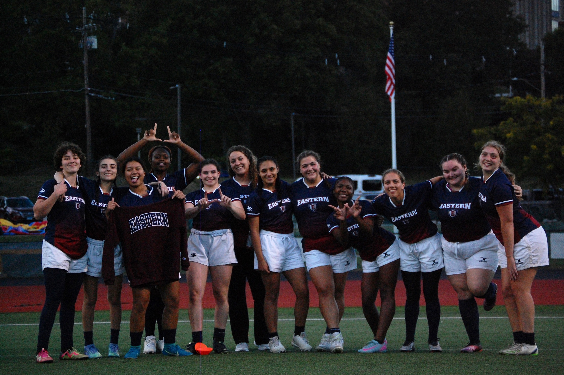 Womens Rugby team posing for a picture on the field