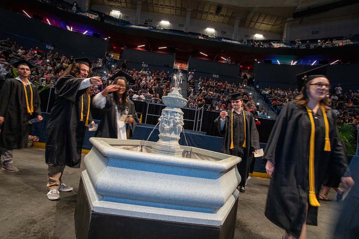 graduating students tossing coins into a fountain for Make a Wish