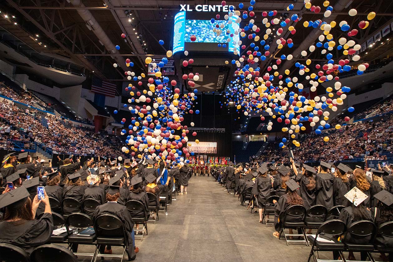 balloons rain from the ceiling as commencement concludes