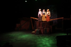student actors standing on a higher area of the stage setting