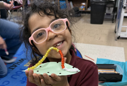 child holding a craft project
