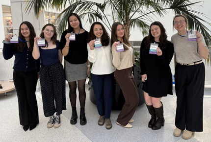 students posing for photo while holding name badges