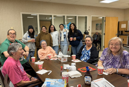 students posing for a photo with senior citizens