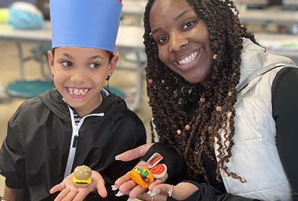 student and child holding small food creations