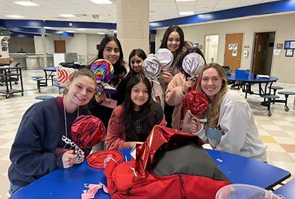 students posing with decorative lollipops