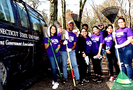 Students posing with gardening equipment