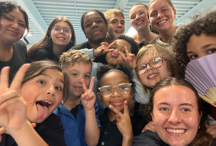 a group of students and children posing for a selfie