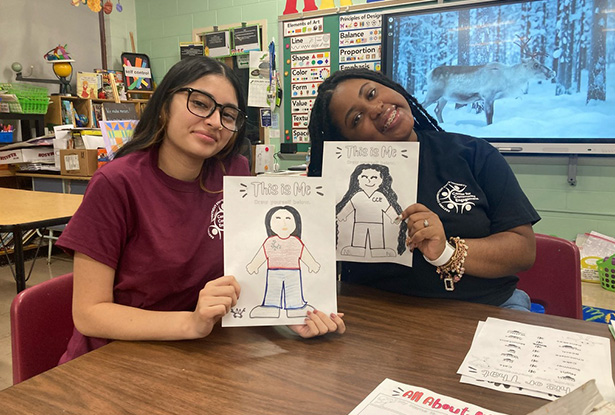 students holding up drawings