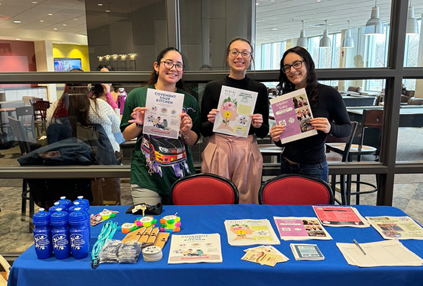 students posing with promotional flyers