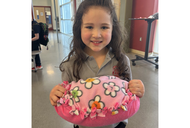 child holding small pink pillow