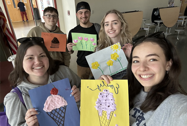 students holding up artwork