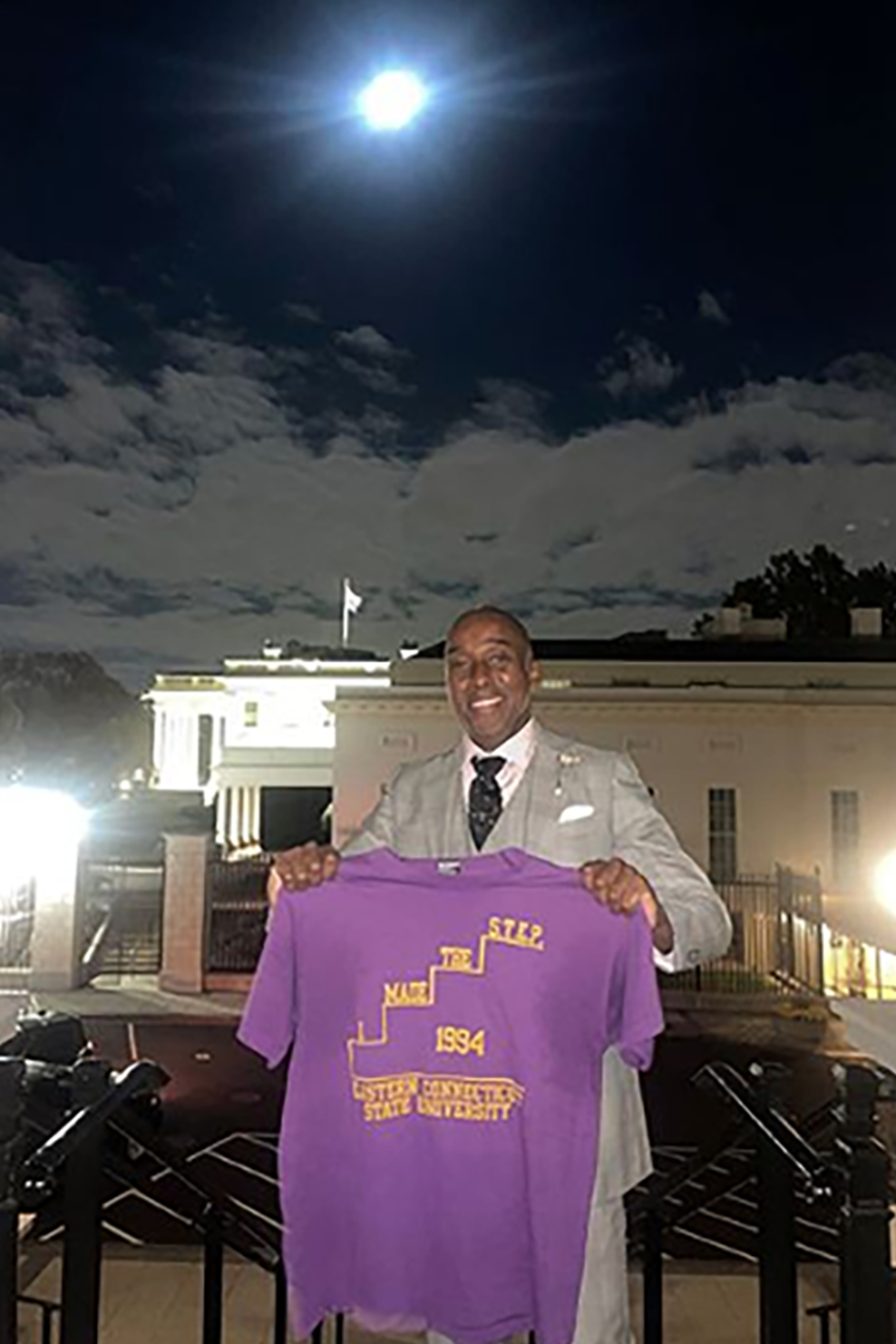 Walner Homere holding up a t shirt