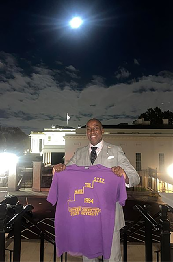 Walner Homere holding up a t shirt