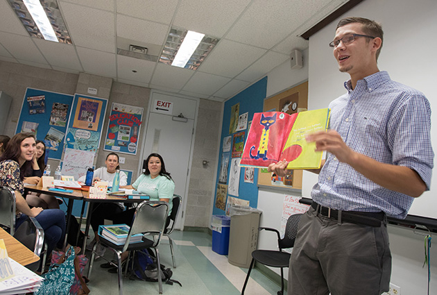 student presenting a child's book in front of a class of peers