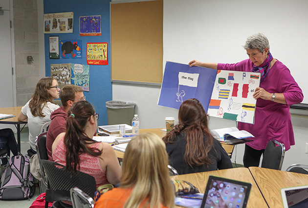 professor in front of a classroom of college students explaining how to integrate picture books into a lesson