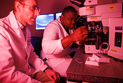 professor and student using lab equipment