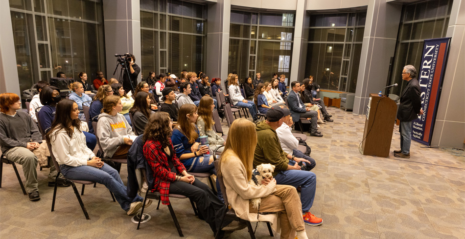 Professor giving lecture in front of crowd