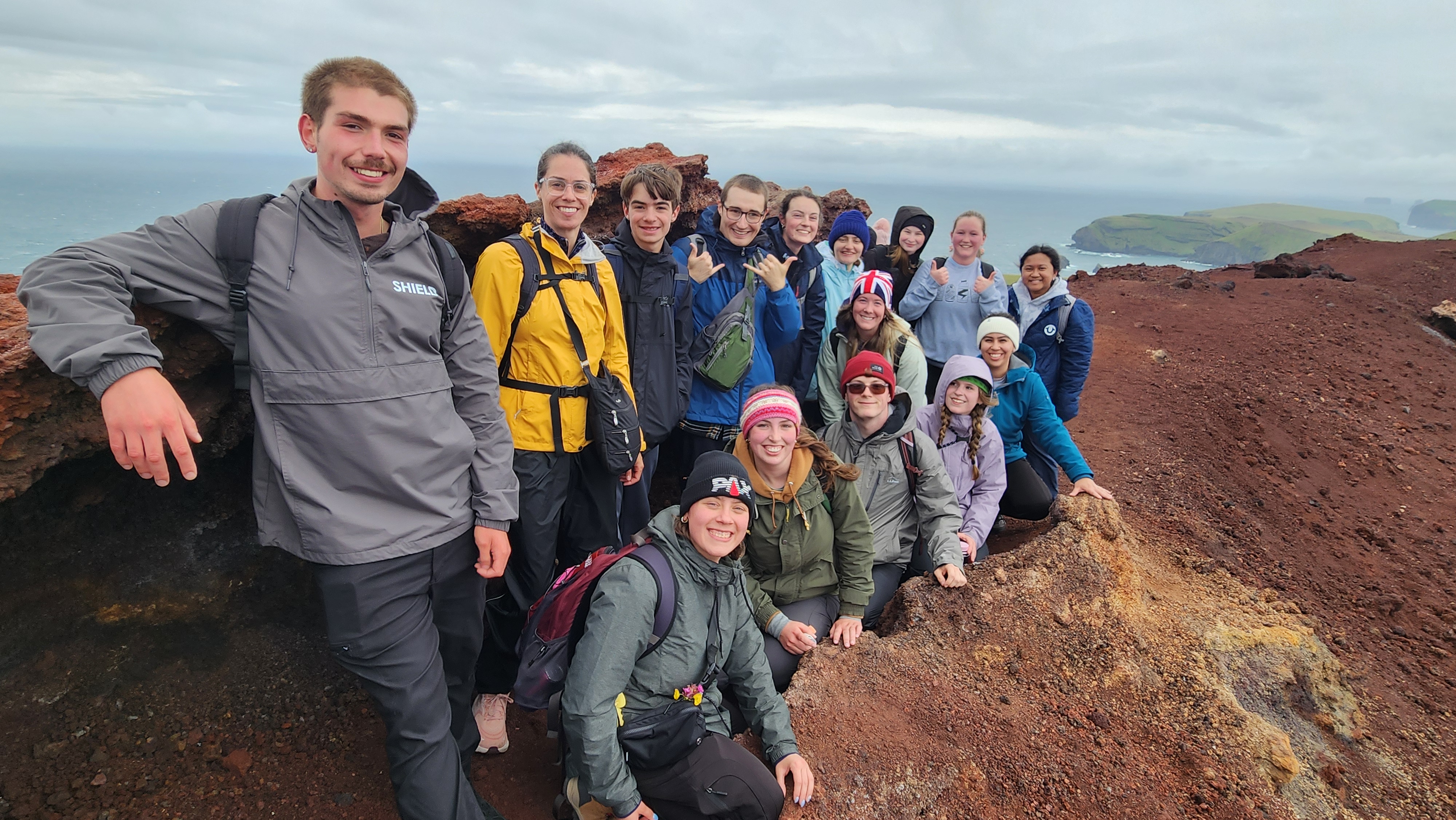 students posing for a photo near a volcano