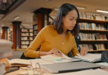 Young, female professional analyzing data in a library.