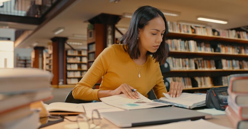 Young, female professional analyzing data in a library.