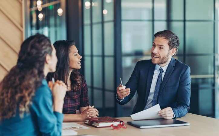 Male accountant shares his expertise and ideas in a meeting with two women.