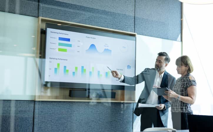 data scientist presenting data on a screen in an office.