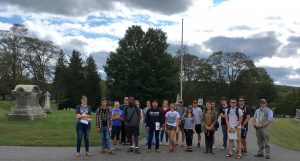 students posing for photo in cemetary