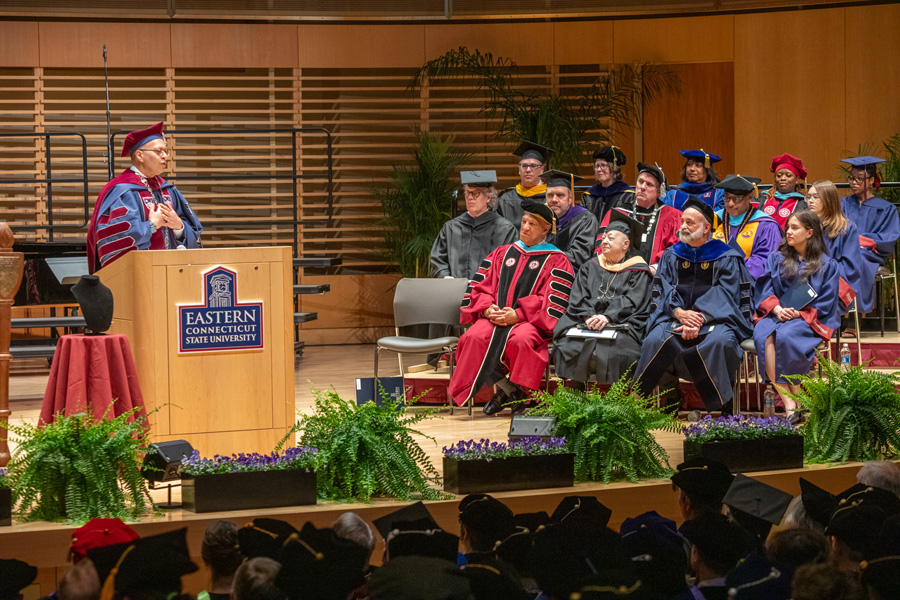 President Ismaili speaking on stage at the Inauguration with guests to the side
