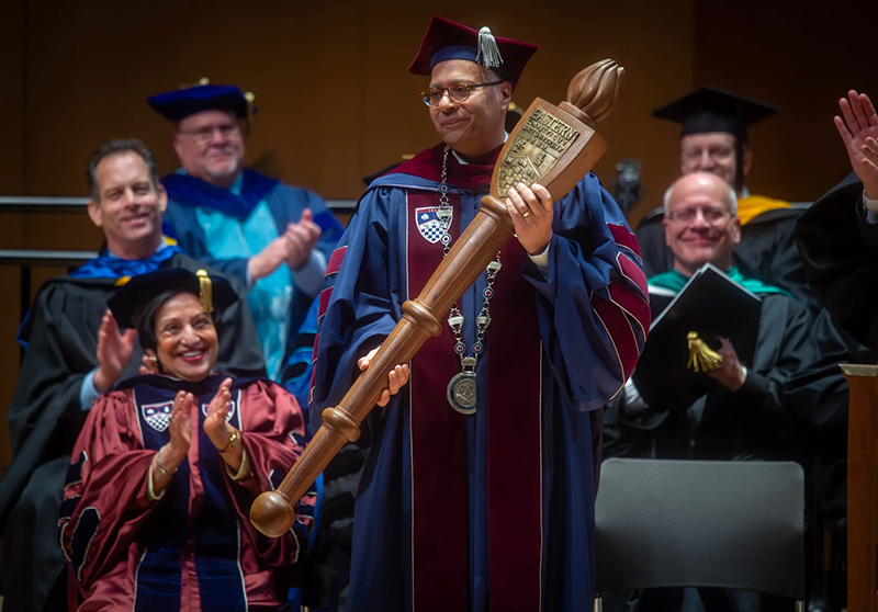 President Karim Ismaili holding the ceremonial mace during his inauguration