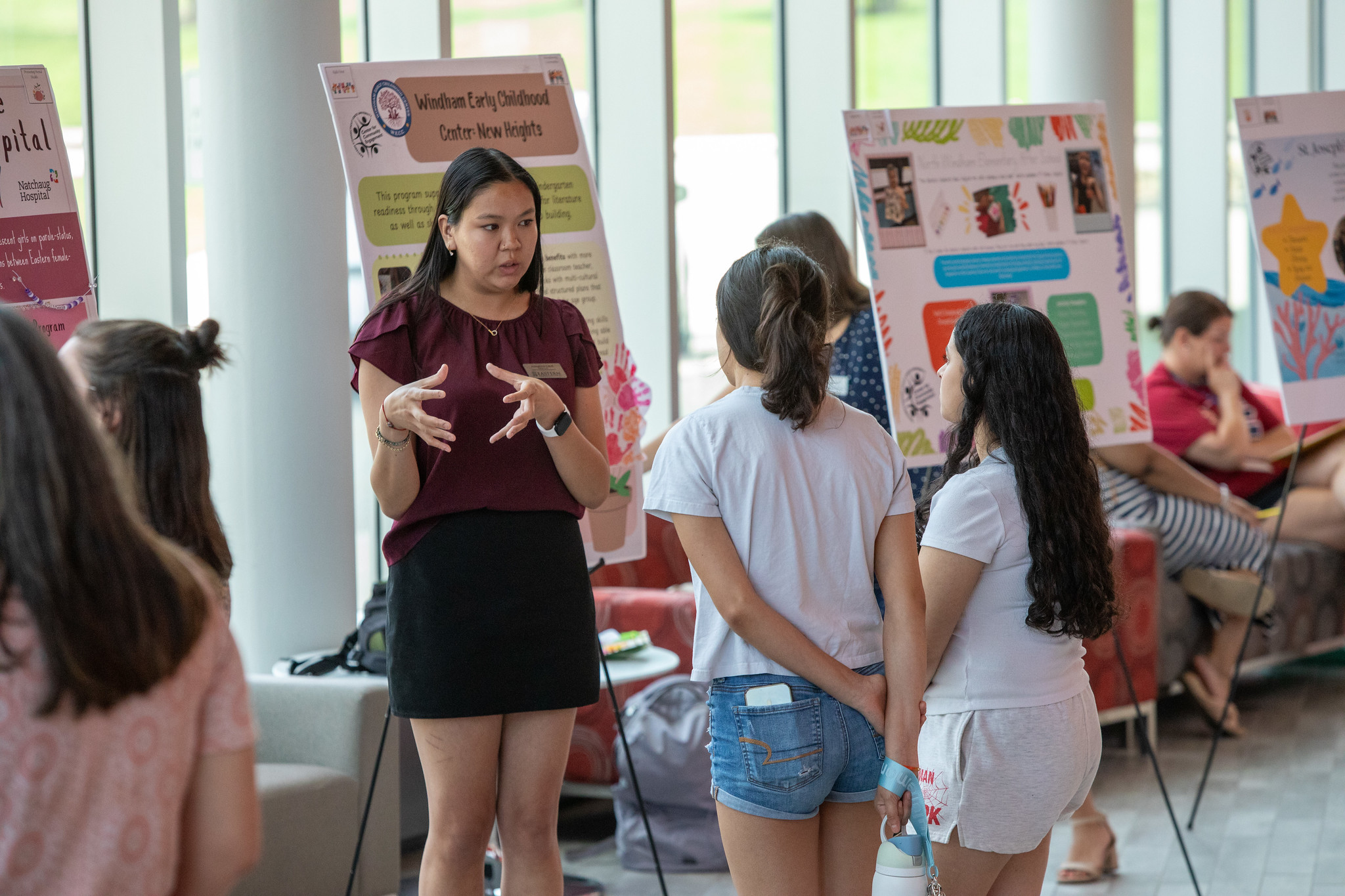 A student explaining her community engagement project at a poster expo
